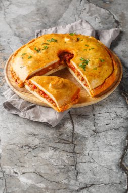 Empanada gallega, İspanyol dolgusunun geleneksel baharatlı turtasıdır. Masanın üzerinde et, dolmalık biber, domates ve soğan kapağı bulunur. Dikey