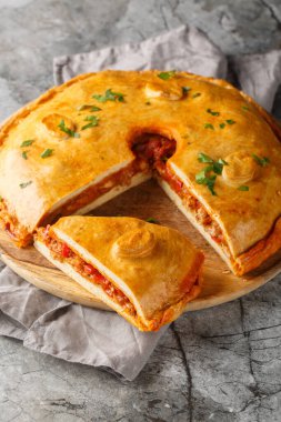 Et, soğan, dolma biber ve domatesle dolu Empanada Gallega İspanyol turtası masanın üstünde. Dikey