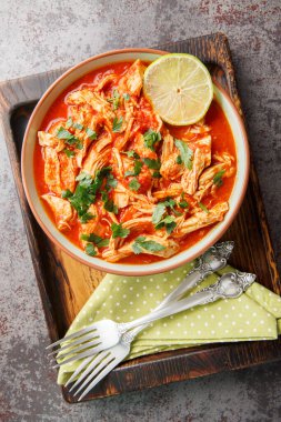 Taco soslu Crock Pot Salsa Chicken tavuk göğsü ve domates salsa sosunu ahşap bir tahtanın üstünde yakın plan çekiyoruz. Yukarıdan dikey üst görünüm