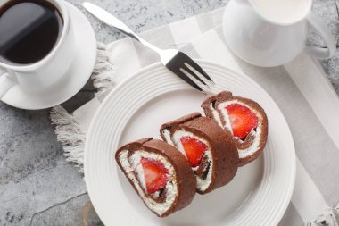 Çilekli çikolatalı kek rulosu ve mermer arka planda krem peynir. Yukarıdan yatay üst görünüm