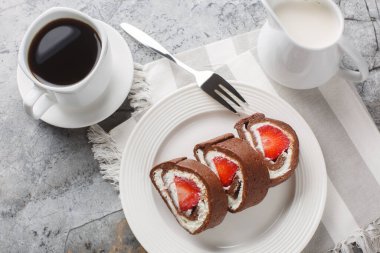 Çilekli çikolatalı kek dilimleri ve yakın plan krem peynirli bir tabak. Yukarıdan yatay üst görünüm