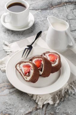 Çilekli çikolatalı İsviçre rulo peynirli kek, masaya yakın kahve ile servis edilir. Dikey