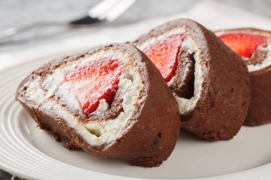 Çilekli çikolatalı kek dilimleri ve yakın plan krem peynirli bir tabak. Yatay