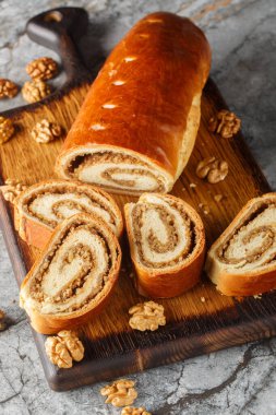 Ev yapımı fındıklı rulo, bejgli, masadaki ahşap tahtaya yakın plan cevizli doldurulmuş geleneksel tatlı ekmek. Dikey