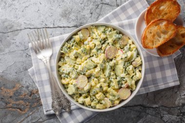 Kaynamış yumurtalı, turplu, yeşil soğanlı ve salatalıklı nefis yaz salatası masada yakın plan kızarmış ekmekle servis ediliyor. Yukarıdan yatay üst görünüm