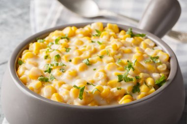 Bol kremalı mısır, tereyağı, masadaki kaseye yakın parmesan peyniri. Yatay