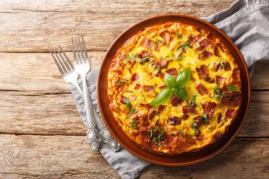 Tavuklu frittata, peynir, yumurta, pastırma ve otlar masanın üstünde. Yukarıdan yatay üst görünüm