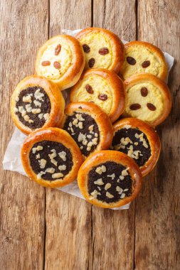 Hakiki Çek Kolache süzme peynir ya da haşhaş tohumlarıyla ahşap masaya yakın plan yapılmış. Yukarıdan dikey üst görünüm