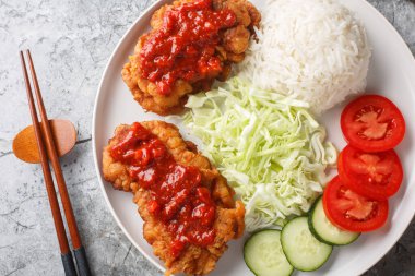 Sambal 'da Ayam geprek Çıtır Tavuk Ezmesi. Masanın üzerinde beyaz pirinç, salatalık, domates ve lahana ile servis ediliyor. Yukarıdan yatay üst görünüm