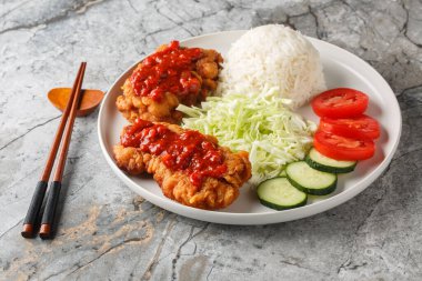 Ayam Geprek Sambal Bawang kızarmış tavuğu beyaz pirinç, salatalık, domates ve lahana ile servis edilir. Yatay