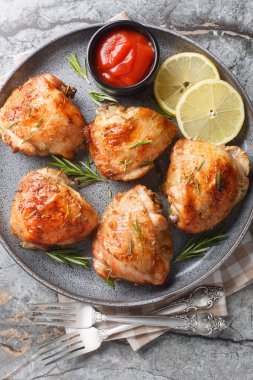 Limonlu biberiyeli tavuk butları masada ketçapla servis edilir. Yukarıdan dikey üst görünüm