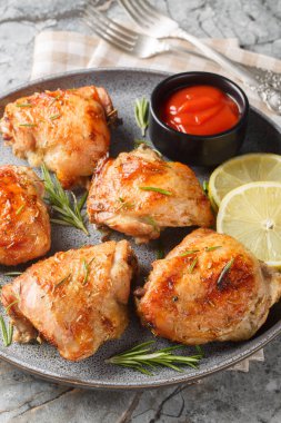 Limonlu biberiyeli tavuk butları masada ketçapla servis edilir. Dikey