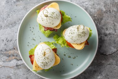 Peynirli, pastırmalı, domatesli ve marullu baharatlı yumurtalardan atıştırmalık sandviç. Yukarıdan yatay üst görünüm