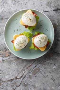 Peynirli, pastırmalı, domatesli ve marullu baharatlı yumurtalı sandviç. Yukarıdan dikey üst görünüm