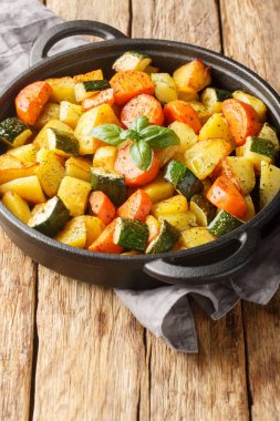 Patates kızartması, havuç, kabak ve yakın plan sarımsak ahşap bir masada kızartma tavasında. Dikey