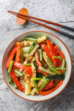 Kızarmış kabak ve dolmalık biberi masanın üstünde yakın plan bir kasede karıştır. Yukarıdan dikey üst görünüm