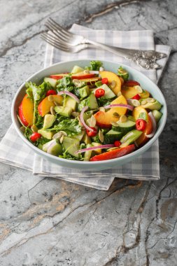Kırmızı soğan, biber, roka, ıspanak ve kabak çekirdekli vejetaryen şeftali salatası. Masanın üzerinde zeytinyağı ile kaplanmış. Dikey