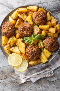 Bifteki, Yunan burger sulu ve lezzetli bir biftekia. Limon yağı soslu çıtır patatesle pişirilmiş, masanın üzerindeki tabağa yakın. Yukarıdan dikey üst görünüm