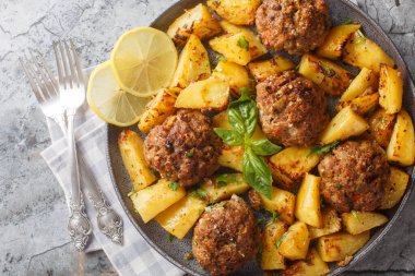 Bifteki Bir Pan Yunan Burgerleri ve Patatesler masadaki tabağa yakın çekim. Yukarıdan yatay üst görünüm