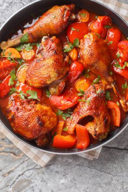 Domates soslu sebzeli haşlanmış horoz. Masanın üstünde tavaya yakın plan. Yukarıdan dikey üst görünüm