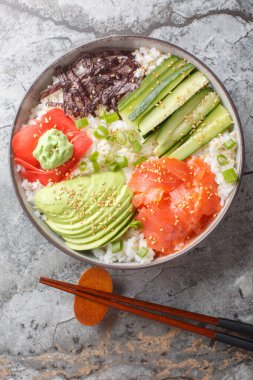 Suşi pirinç kasesi tarifi suşi kalitesinde deniz ürünleri, en taze malzemeler ve sofrayı sağlıklı ve tatmin edici bir şekilde kapalı tutmak için yumuşak suşi pilavından oluşur. Yukarıdan dikey üst görünüm