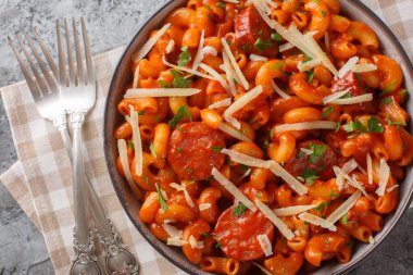 Sosisli Gochujang makarnası masanın üzerindeki tabakta İtalyan-Koreli karışımı mükemmel bir yakın plan. Yukarıdan yatay üst görünüm