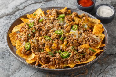 Geleneksel nachos kıymalı, çedar peynirli ve biberli ve masada soslu. Yatay