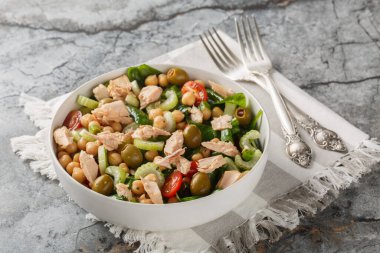 Lezzetli nohut ton balığı salatası ve taze sebzeler gibi sağlıklı malzemeler masanın üstündeki kasede yakın plan otlar. Yatay