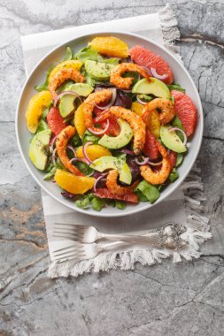 Portakallı taze Cajun karides salatası, avokado, greyfurt ve masada yakın plan yeşil yapraklar. Yukarıdan dikey üst görünüm