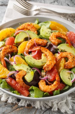 Portakallı taze Cajun karides salatası, avokado, greyfurt ve masada yakın plan yeşil yapraklar. Dikey