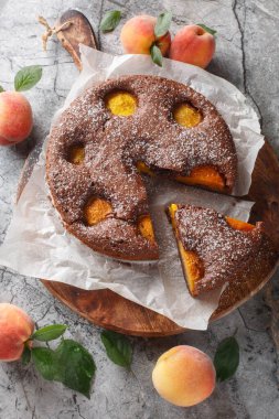 Masanın üzerinde taze şeftalili çikolatalı turta. Tahta tahtaya yakın plan. Yukarıdan dikey üst görünüm