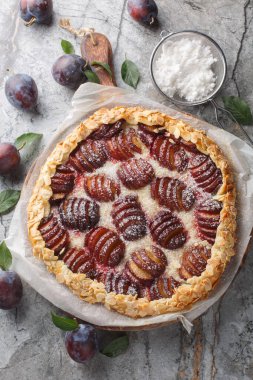 Badem ve pudra şekerli yaz erikli galet. Tahta tahtaya yakın plan. Yukarıdan dikey üst görünüm