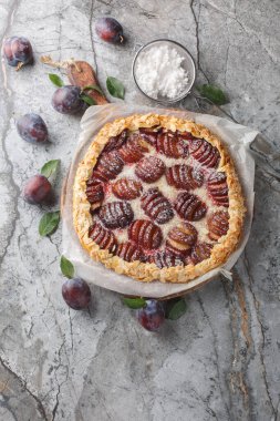 Ev yapımı erikli galette kek, badem ve masa üzerindeki tahta tahtaya yakın plan şeker. Yukarıdan dikey üst görünüm