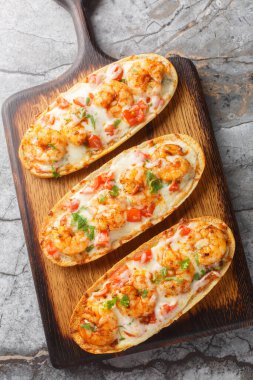 Karidesli, peynirli, sarımsaklı ve domatesli sıcak sandviçler masanın üzerinde. Yukarıdan dikey üst görünüm