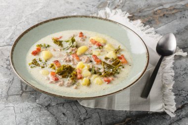 Geleneksel Zuppa Toscana ya da İtalyan sosisi, lahana, kızarmış domuz pastırması ve patatesli Toscana çorbası masanın üstünde. Yatay