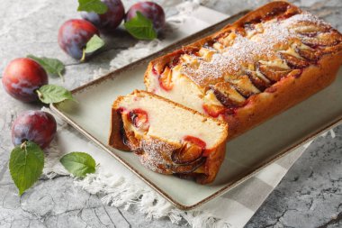 Fresh Plum Cake with yogurt and olive oil, the sponge is moist and flavourful closeup on the plate on the table. Horizonta clipart