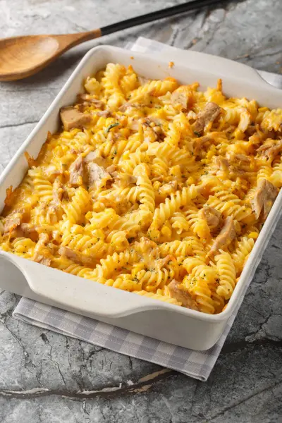 stock image Tuna casserole pasta bake with a creamy sauce, sweet corn and crunchy topping, baked until golden closeup on the baking dish on the table. Vertica