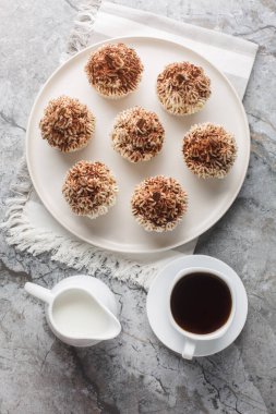 Hassas Tiramisu kekleri kremalı mascarpone kremalı ve kakaolu ve yakın planda kahve ile servis edilen bir tabakta. Yukarıdan dikey üst görünüm