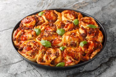 İtalyan sosisi, Mozzarella, domates ve fesleğen ile dolu Rustik pizza ruloları masadaki bakong çanağının üzerinde. Yatay