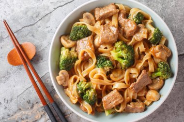 Asya usulü sığır eti, erişte, mantar ve brokoliyi yakın plan bir masada. Yukarıdan yatay üst görünüm