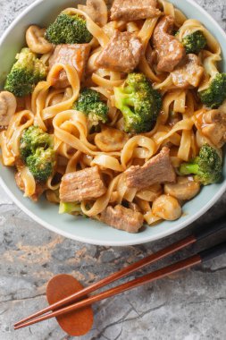 Bir kase lezzetli etli teriyaki brokoli, erişte ve baharatlı soslu mantarlı masaya yakın. Yukarıdan dikey üst görünüm