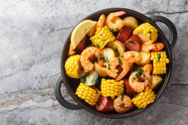 Masada karides, mısır, patates, sosis ve limonlu ev yapımı Cajun deniz mahsulleri var. Yukarıdan yatay üst görünüm