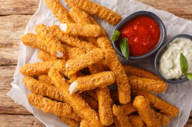 Dip fried Breaded tavuk göğsü şeritleri ketçapla servis edilir ve parşömen üzerine yakın plan mayonez sergilenir. Yukarıdan yatay üst görünüm