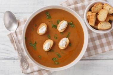 Fransız balık çorbası püresi, kızarmış ekmek ve aioli sosu ahşap bir masada yakın plan. Yukarıdan yatay üst görünüm