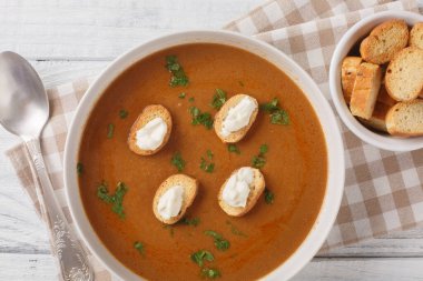 Zengin balık çorbası Çorba de Poisson kızarmış ekmek ve aioli sosuyla ahşap bir masada yakın plan servis edilir. Yukarıdan yatay üst görünüm