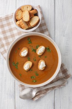 Lezzetli Fransız Çorbası ve beyaz balık, ahşap masadaki kase üzerinde kıtır ekmek ve aioli sosuyla birlikte hafif bir vermut stokunda kaynatılıyor. Yukarıdan dikey üst görünüm