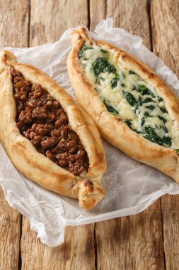 Tahta masaya yakın ıspanaklı kıyma ve peynirli Türk Pide pizzası. Dikey