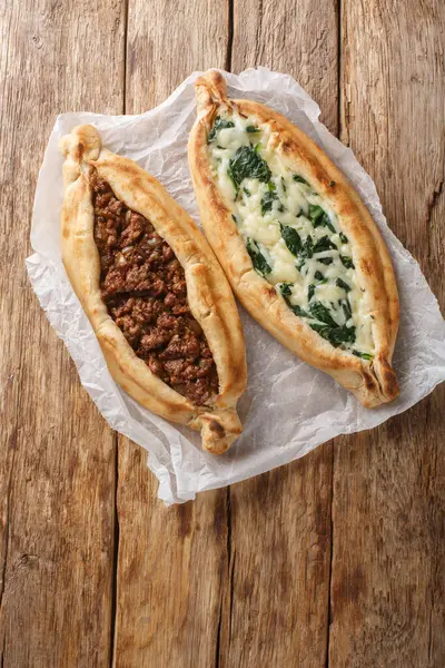 Köfte, peynir, ıspanak ve otlarla dolu Türk Pide Düz Ekmeği. Masanın üzerinde. Yukarıdan dikey üst görünüm