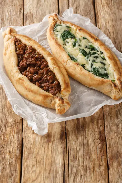 Köfte, peynir, ıspanak ve otlarla dolu Türk Pide Düz Ekmeği. Masanın üzerinde. Dikey