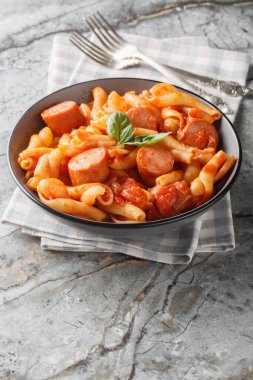 Domatesli, soğanlı, sosisli ve baharatlı Treccione makarnası masanın üstünde. Dikey